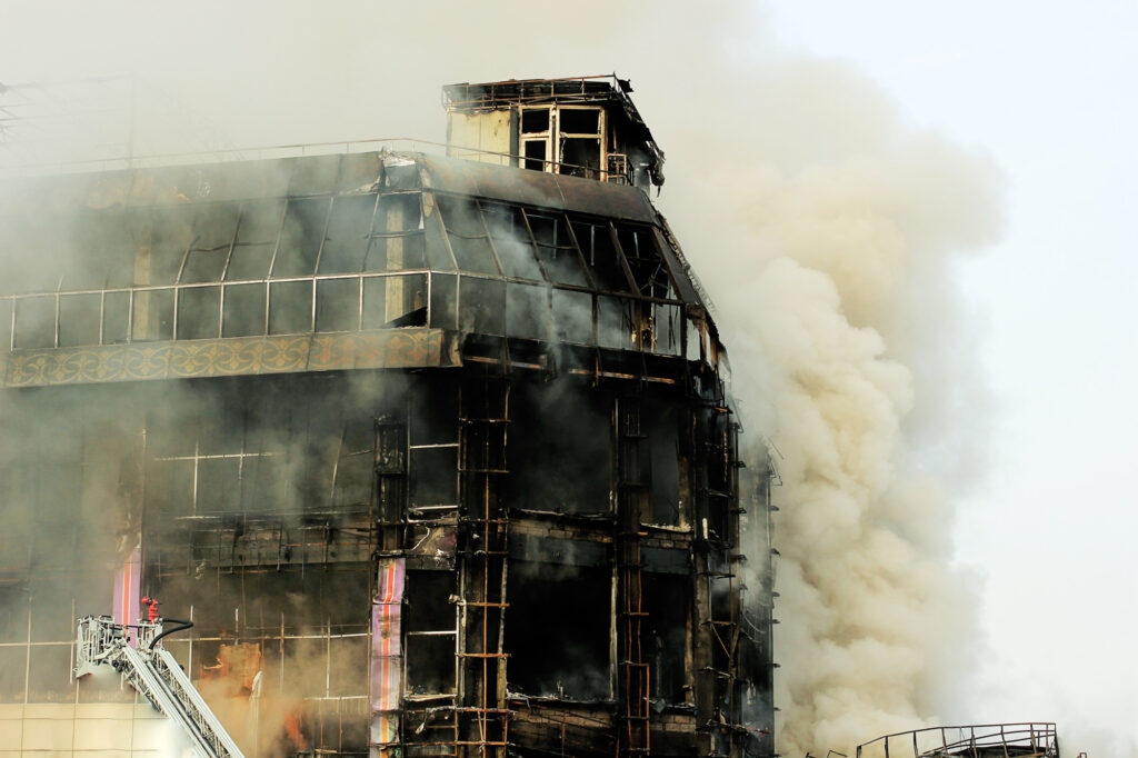 Smoke billowing from a burning multi-story industrial or commercial building.
