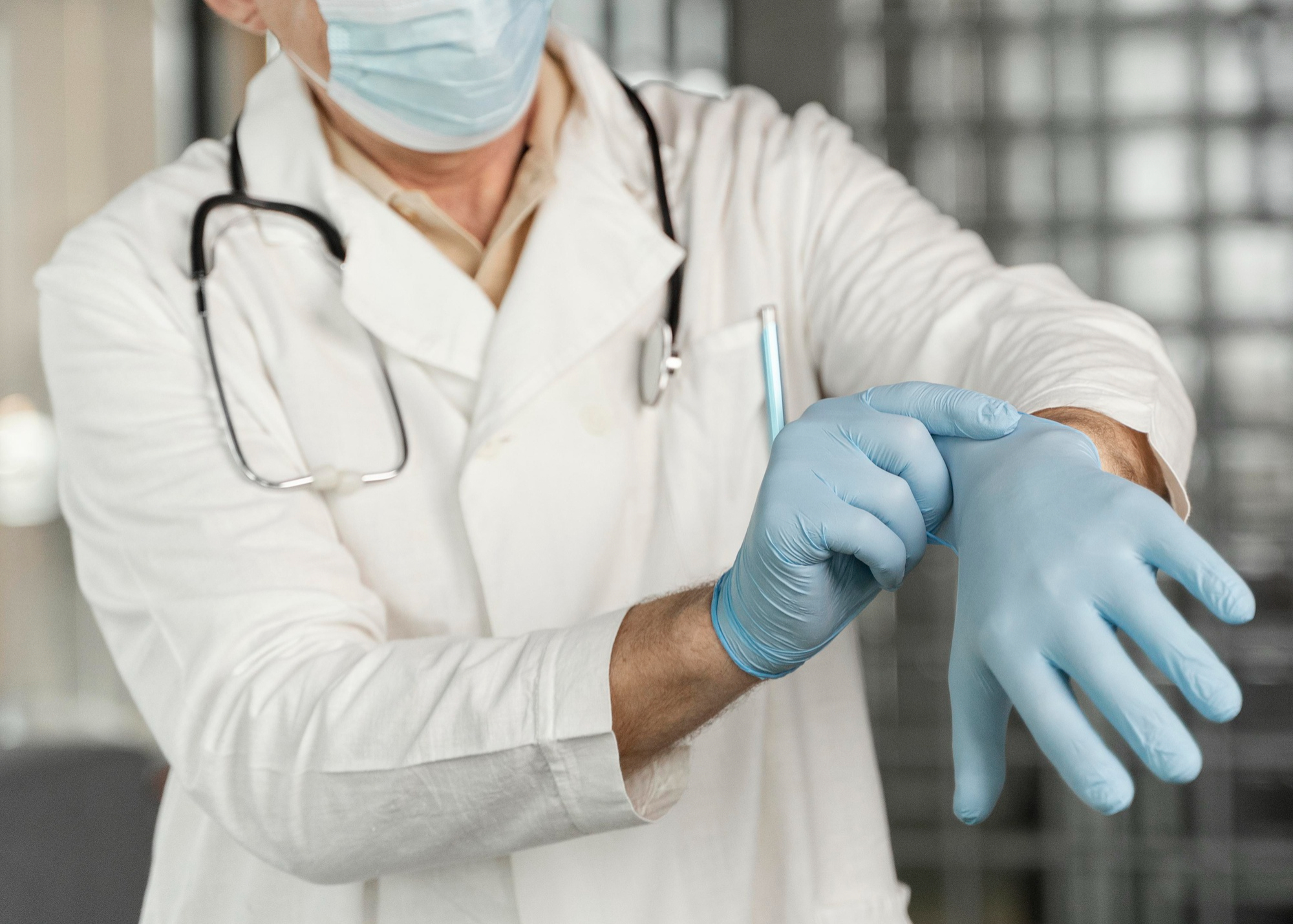 Doctor wearing gloves and mask preparing for a procedure.